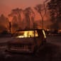 Flames burn inside a van as the Camp Fire tears through Paradise, Calif., on Thursday, Nov. 8, 2018. Tens of thousands of people fled a fast-moving wildfire Thursday in Northern California, some clutching babies and pets as they abandoned vehicles and struck out on foot ahead of the flames that forced the evacuation of an entire town and destroyed hundreds of structures. (AP Photo/Noah Berger)