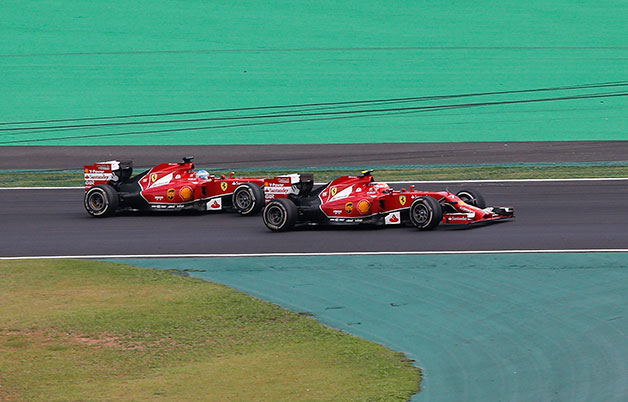 Ferrari drivers Kimi Raikkonen and Fernando Alonso race at the 2014 Brazilian F1 Grand Prix.