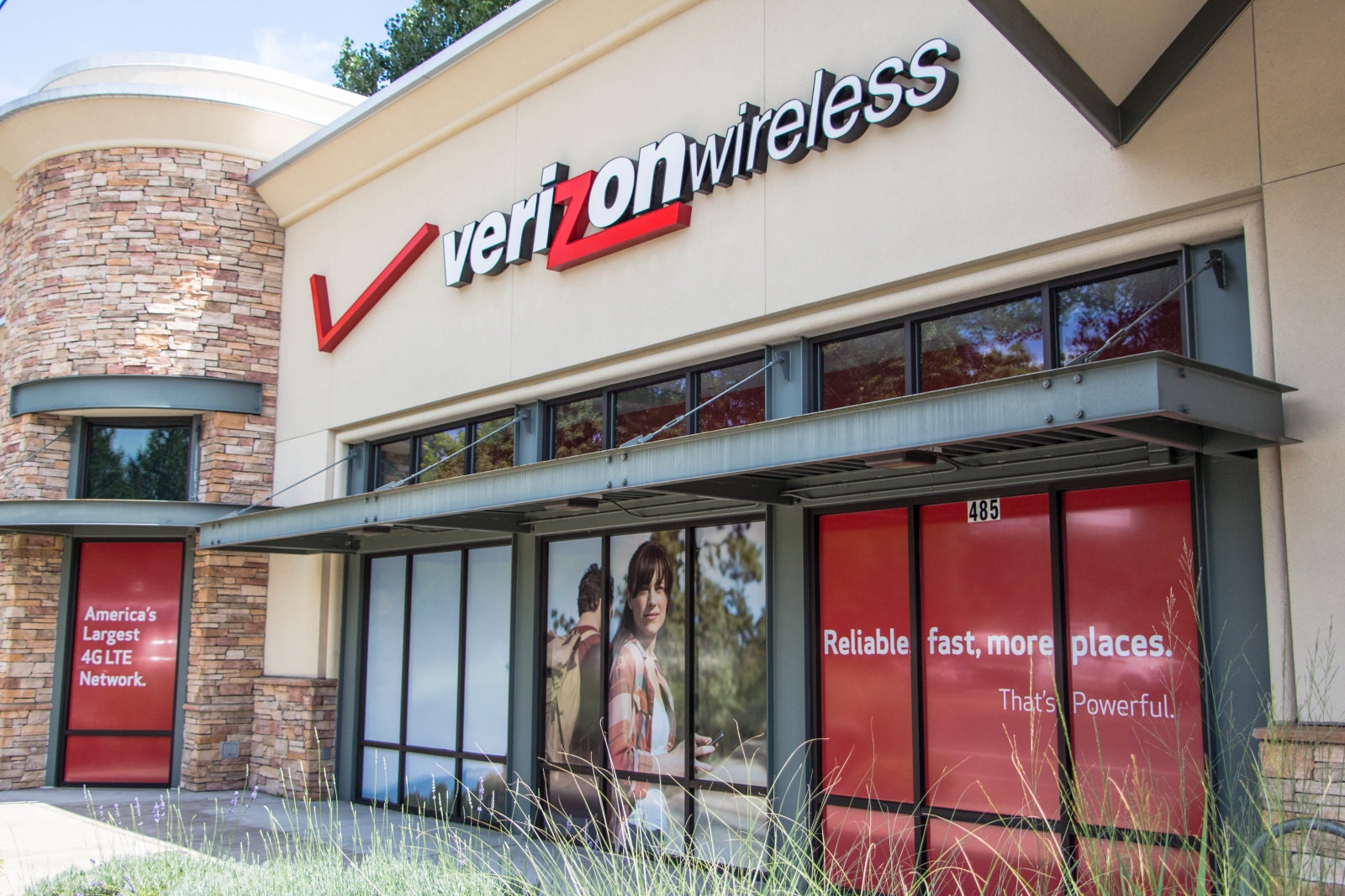 Eugene, Oregon, USA - July eight, 2014: Verizon Wireless Store space in Eugene, Oregon. Verizon sells cell phone services and products in addition to cable across america with more than a a thousand locations.  Right here's a portray of Verizon's promoting on the aspect of the building as vehicles circulate by.