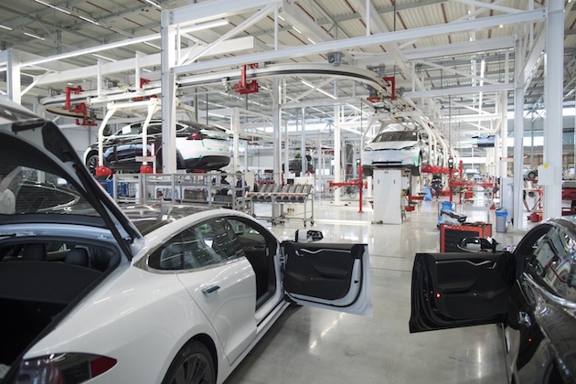 The front doors of Tesla Model X sports utility vehicles (SUV) sit open during assembly for the European market at the Tesla Motors Inc. factory in Tilburg, Netherlands, on Friday, Dec. 9, 2016. A boom in electric vehicles made by the likes of Tesla could erode as much as 10 percent of global gasoline demand by 2035, according to the oil industry consultant Wood Mackenzie Ltd. Photographer: Jasper Juinen/Bloomberg