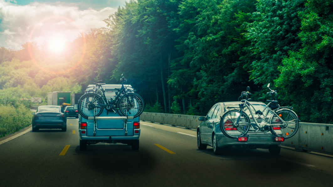 car_and_minibus_transport_bicycles_on_a_rack_on_highway_in_sunset1.jpeg