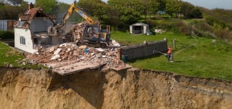 Pictured: Farmhouse left hanging over cliff edge demolished to stop it plunging to beach below