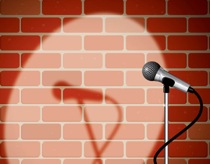 Spotlight shining on a microphone in front of a brick wall