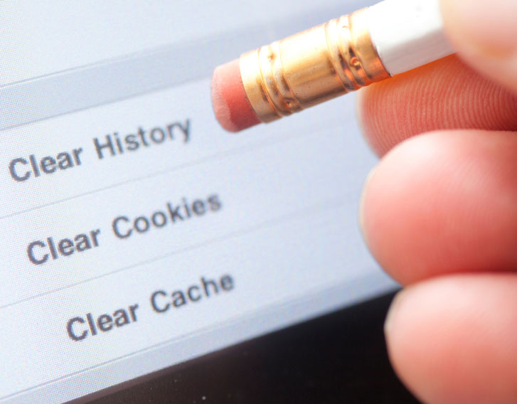 Person pointing a pencil eraser at a screen that is asking to clear history, cookies, or cache